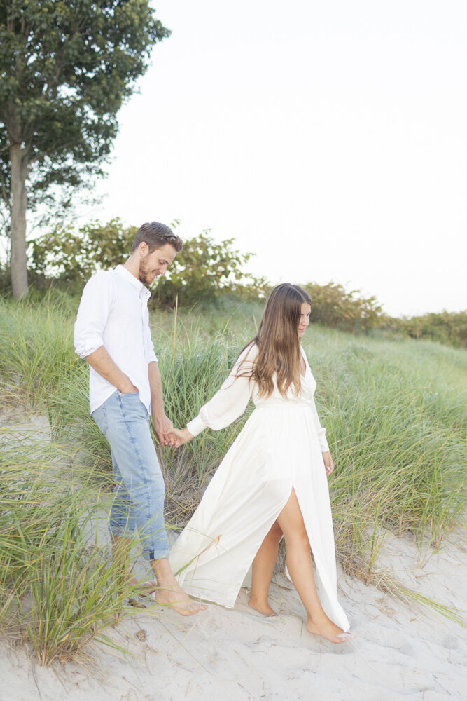 couple walking together through the beach grasses