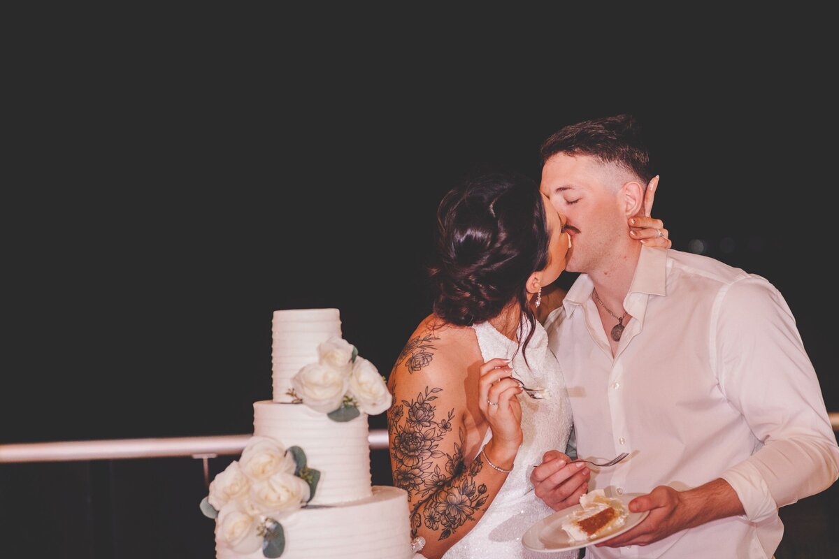 Bride and groom kissing after cutting cake at wedding in Cancun