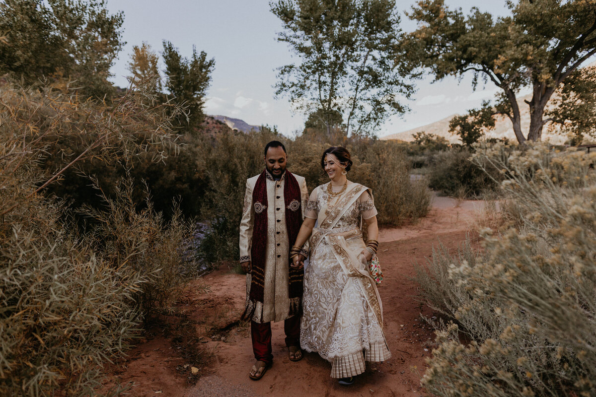 bride and groom walking through Jemez Springs in their Indian wedding attire