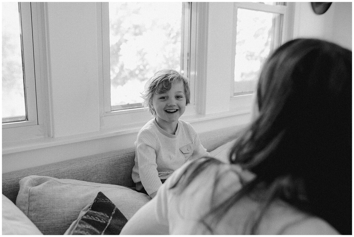 Young child sitting by windows at  sweet at home family session in Austin by Amber Vickery Photography