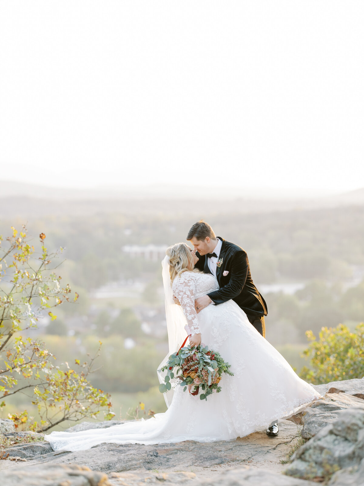 groom dips bride atop mountain lookout in Arkansas