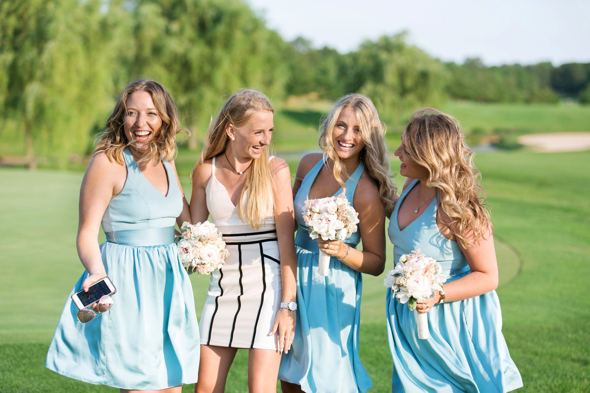 bride and bridesmaids smiling and laughing on golf course at Willow Creek Golf and Country Club