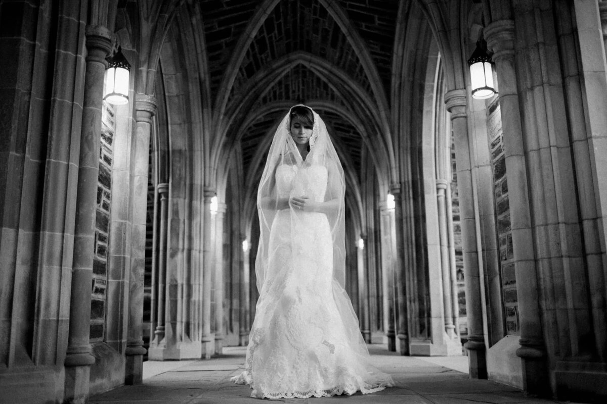 A bride holding her veil across the front of her body