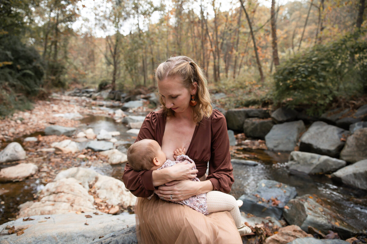 A mother breastfeeds her daughter during their Baltimore County lifestyle family session in Cromwell Valley Park.