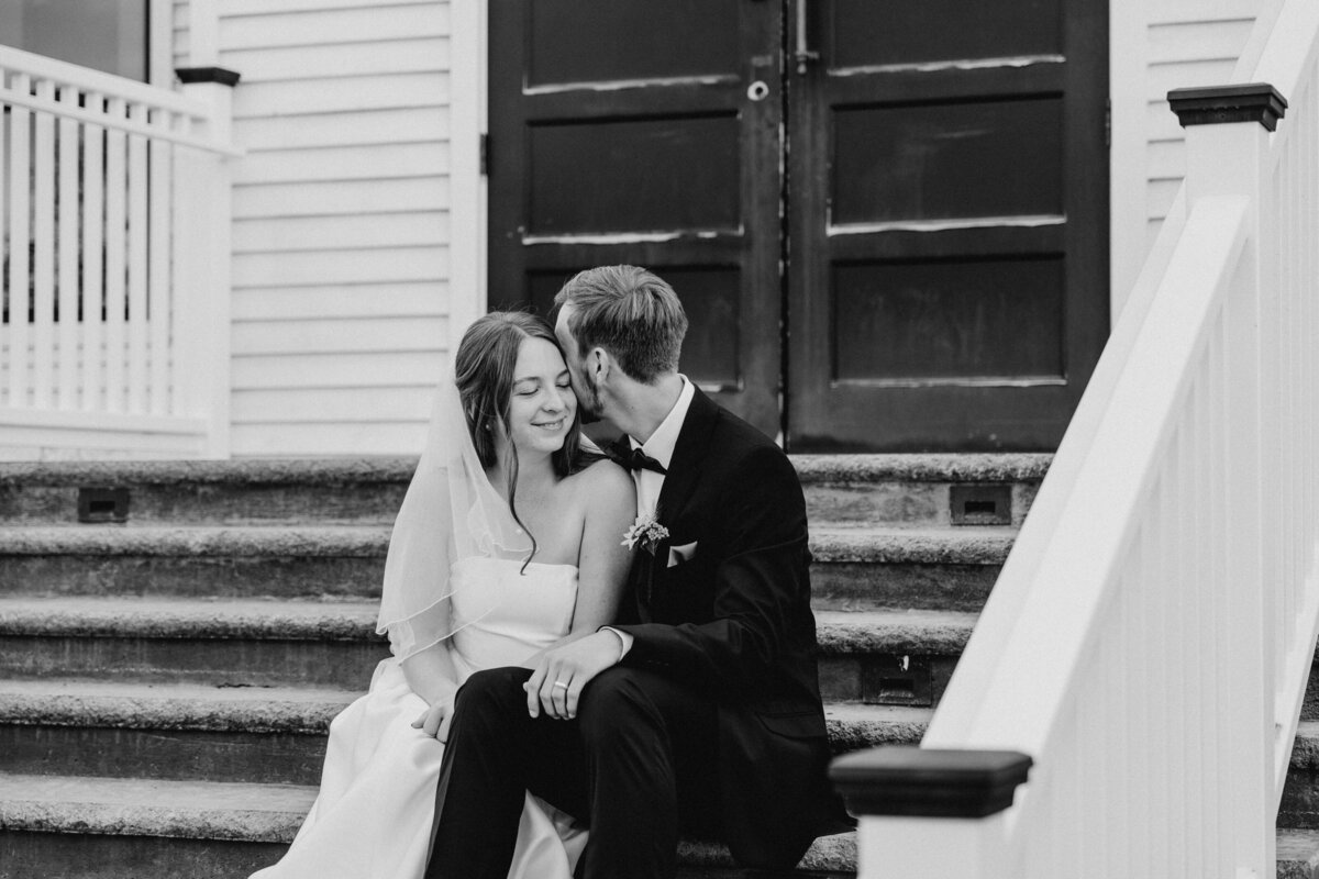 Hailey and Spencer sit in front of the white chapel on their wedding day at Grace City Church in Wenatchee, Washington.