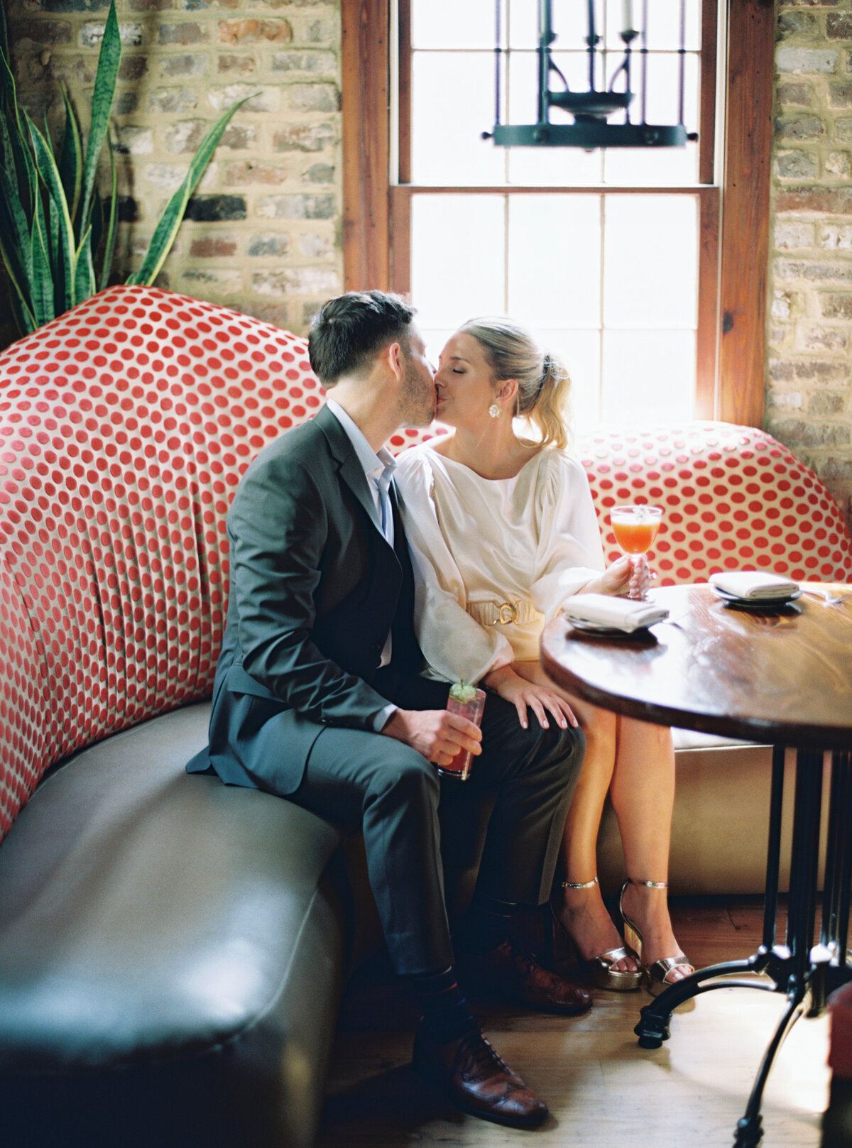 Private engagement photos upstairs at the bar at Husk. Film photographer based in Charleston, SC.
