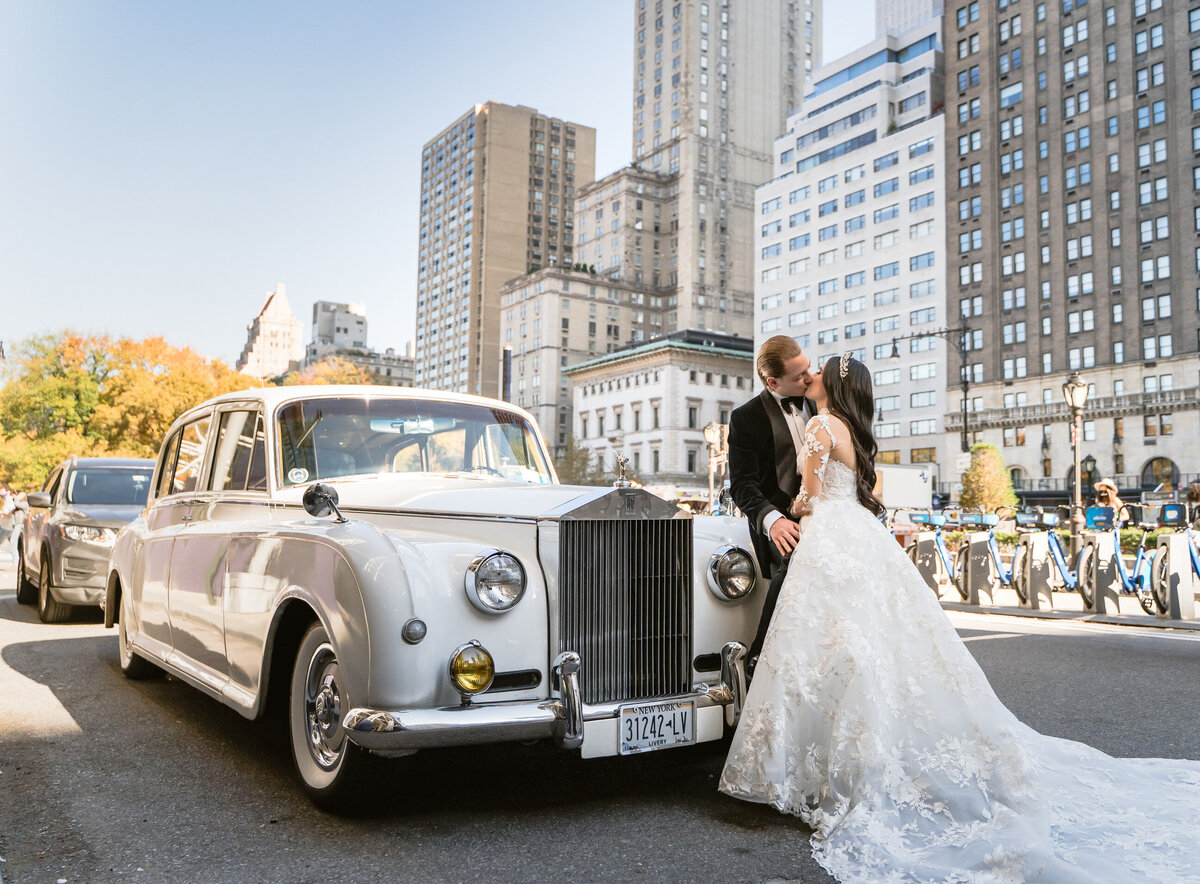 bride and groom in front of limo