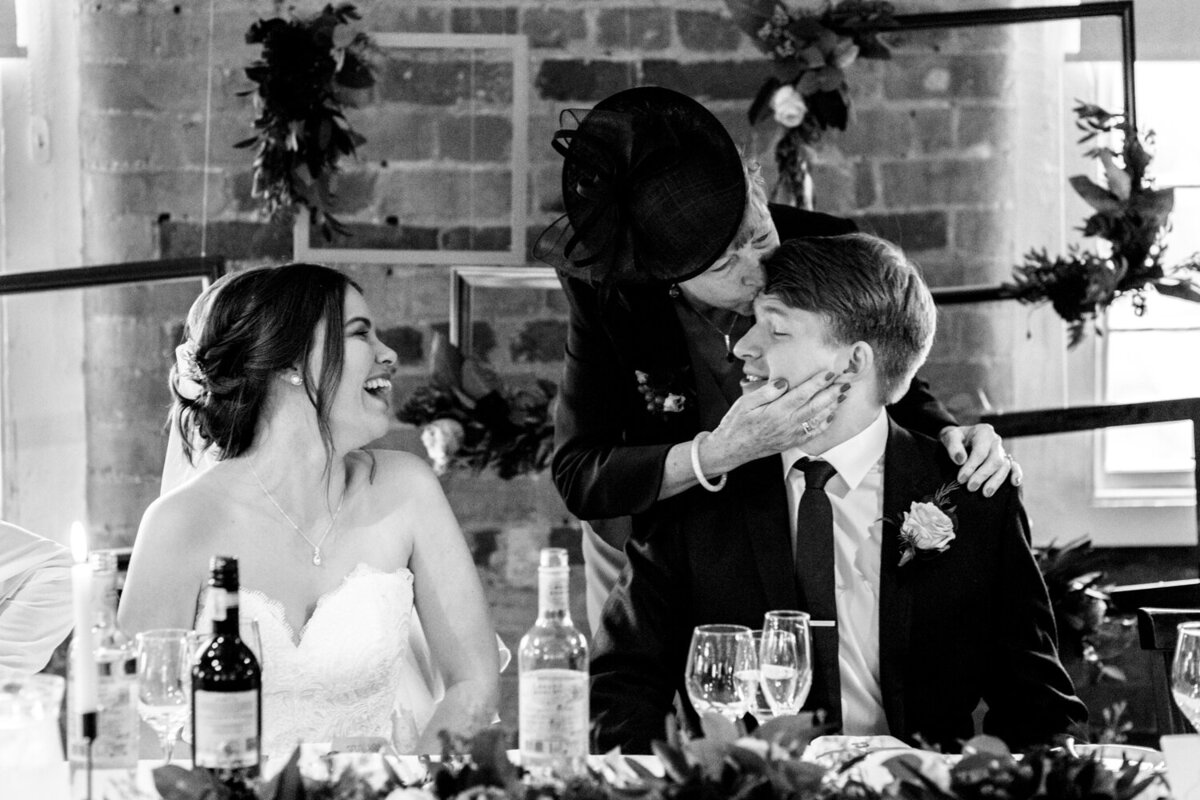 mother of groom kissing grooms forehead