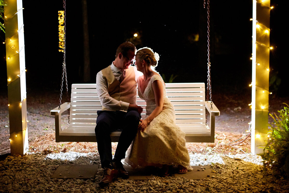 Bride and groom on swing at night at the Mackey House, Savannah wedding photographer