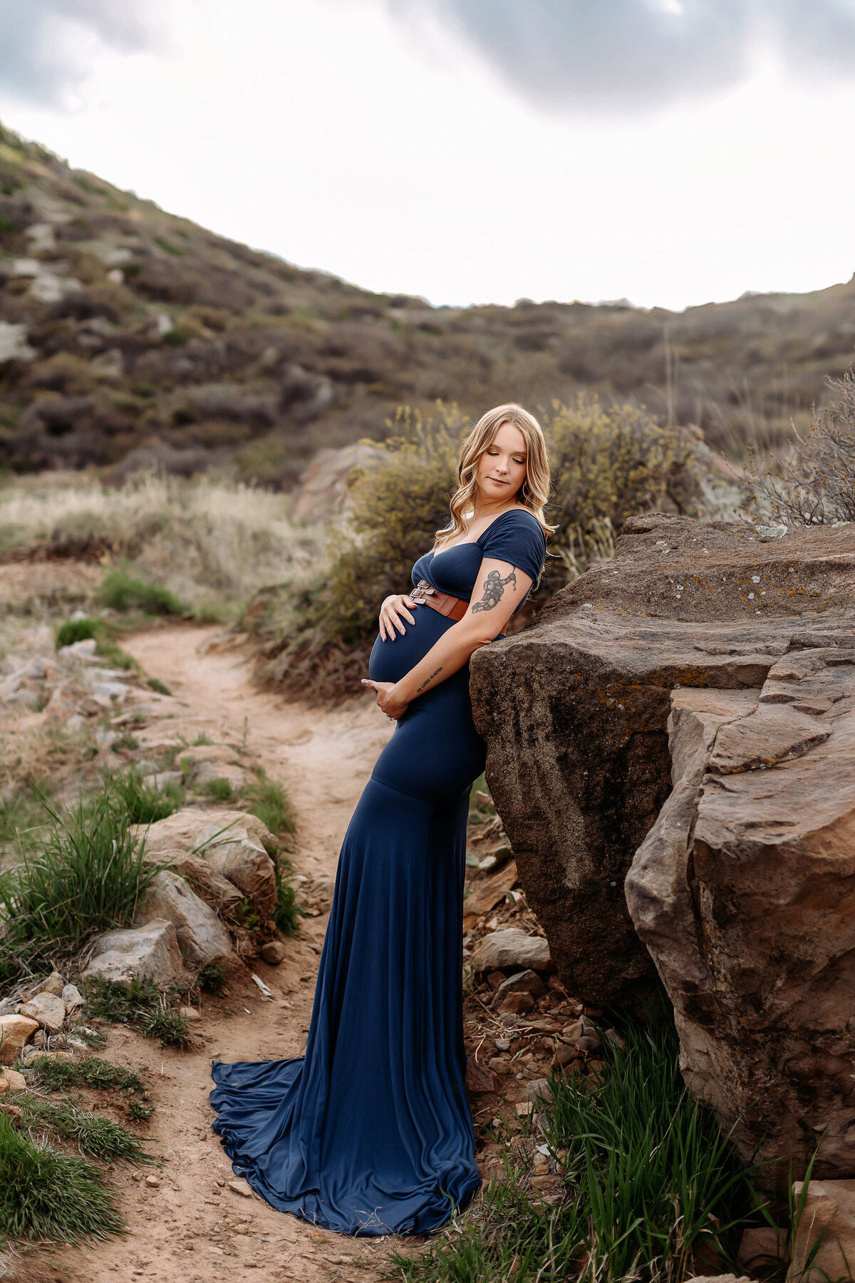 pregnant mom leaned against rock in denver for her maternity photos