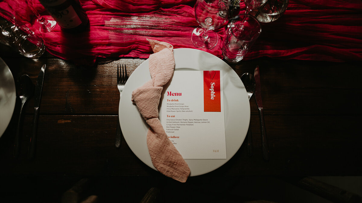 A plate with pink wedding stationery at Paintworks in Bristol. 