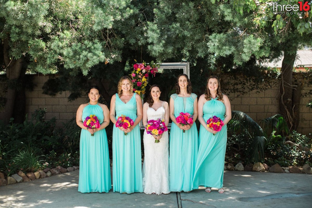 Bride poses with her Bridesmaids wearing seafoam colored dresses
