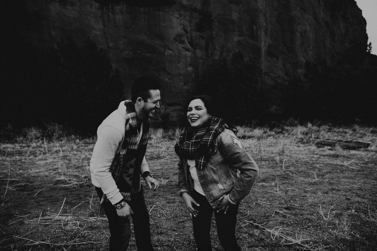 engaged couple laughing together in New Mexico desert