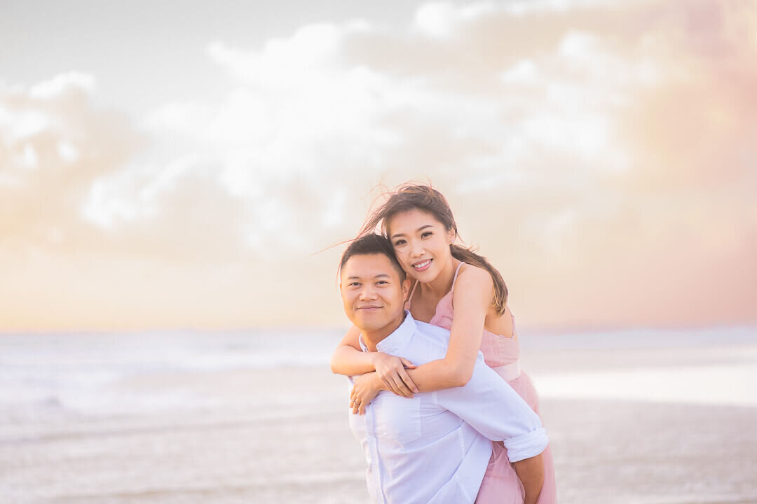 girl piggyback on boy during couples engagement session on Gold Coast beach