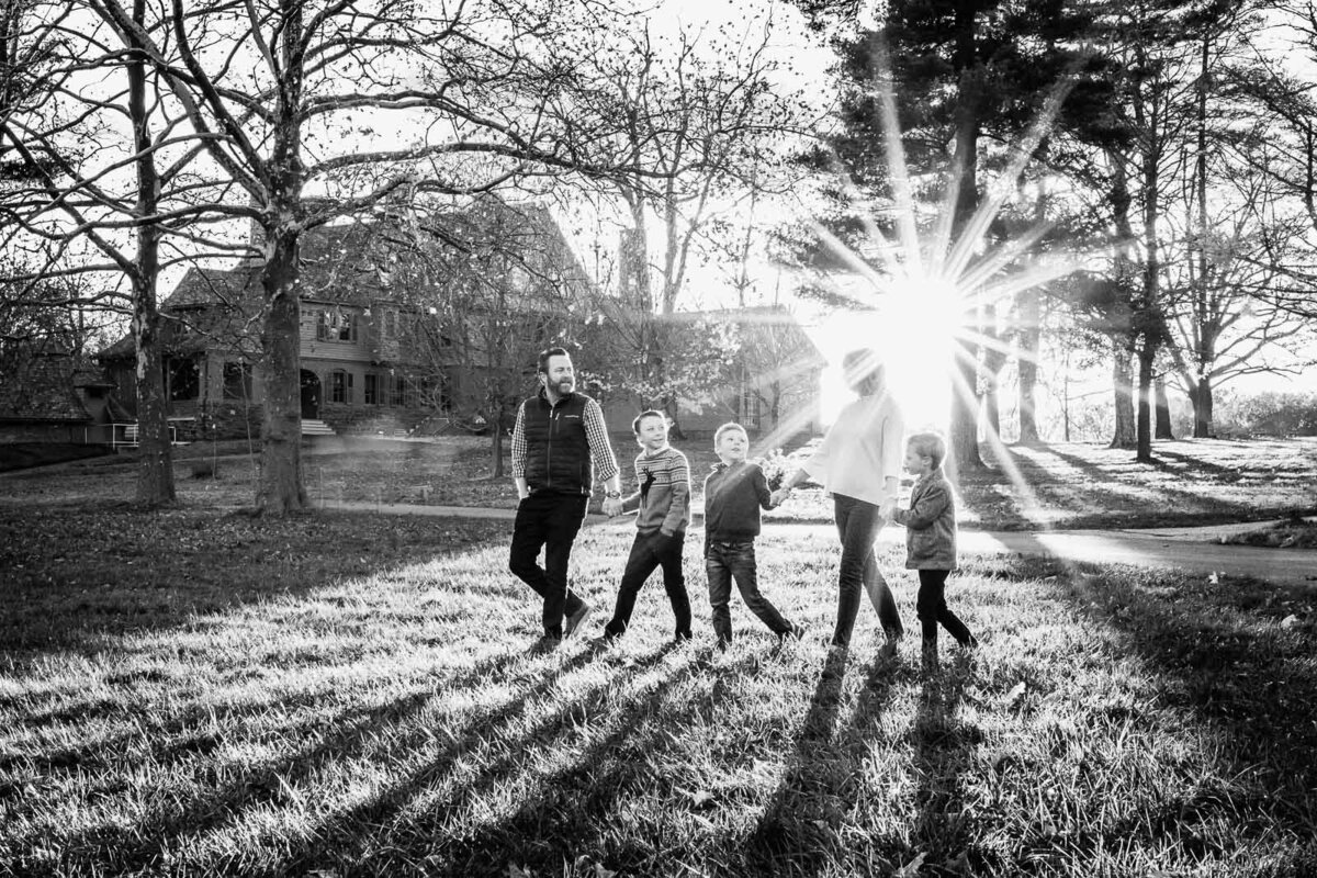 family walking with sun behind at sagamore hill photo session