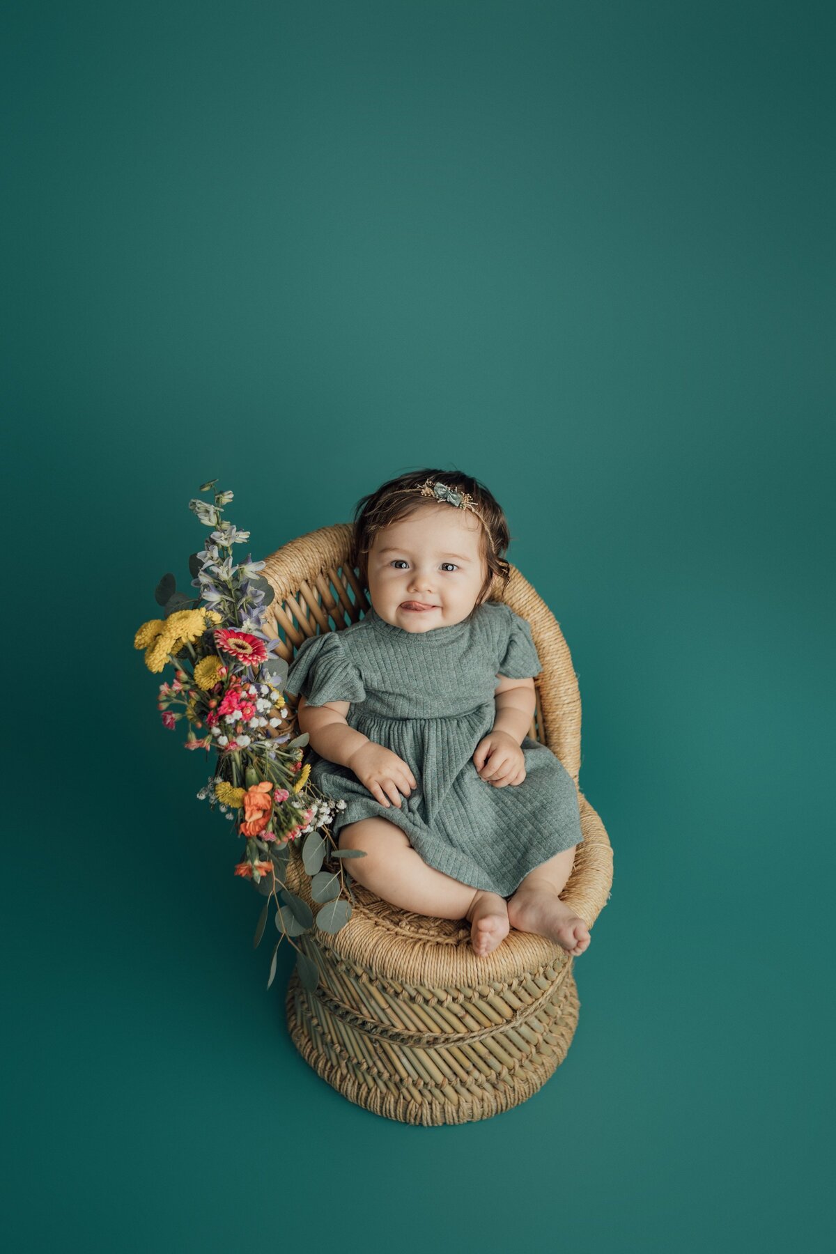 6 month girl on rattan chair during milestone session in st. pete