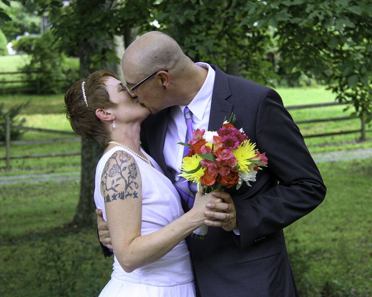 Couple shares a kiss on their family's farm after their intimate wedding ceremony