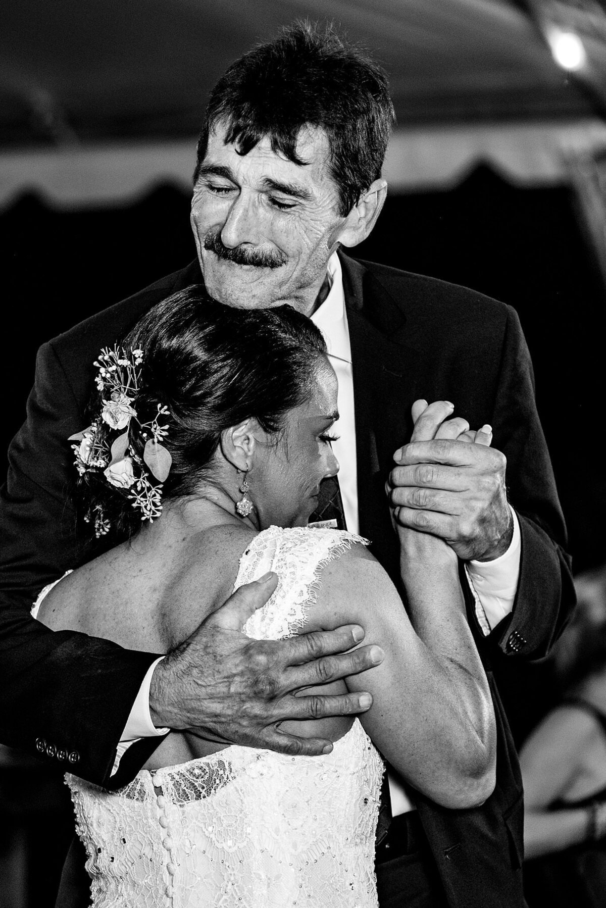 Father of the bride hugging his daughter while dancing emotionally.