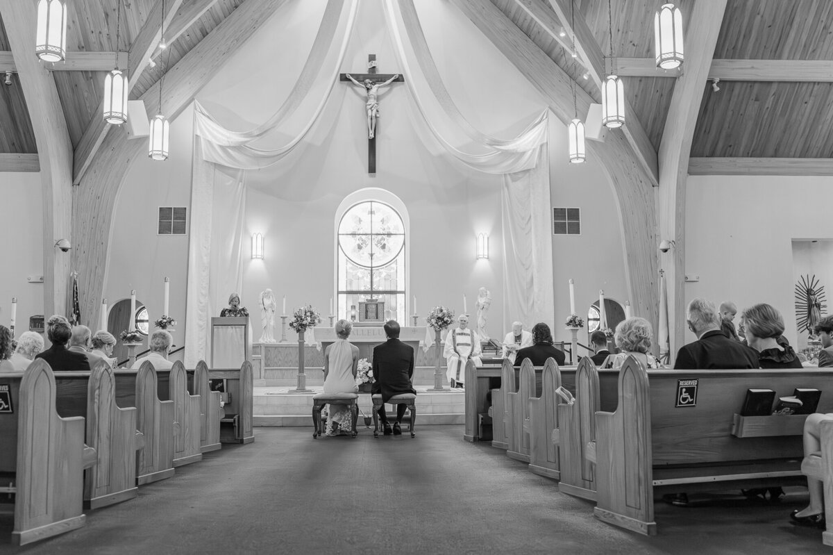 A couple getting married in a catholic church in Fuquay Varina surrounded by their friends and family for their Raleigh wedding photos