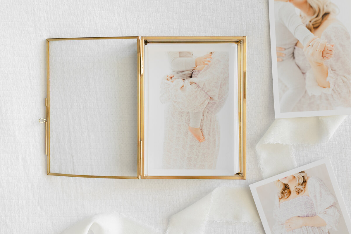A photo of a glass box of prints featuring a pregnant mother and her toddler by northern virginia maternity photographer