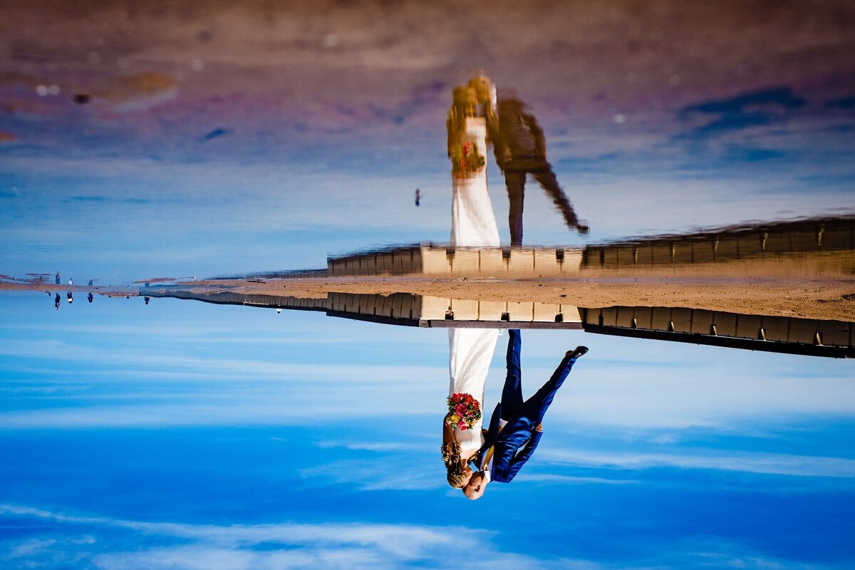 A couple is reflected in Lake Michigan during a Firehouse Chicago wedding.