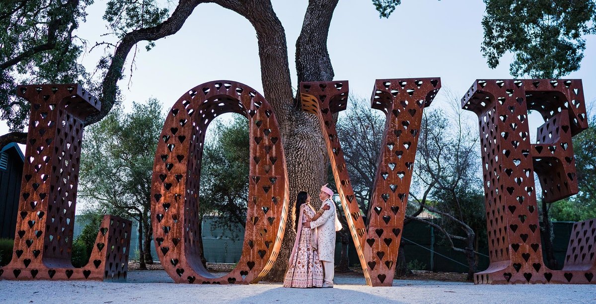 Couple in front of Love sign