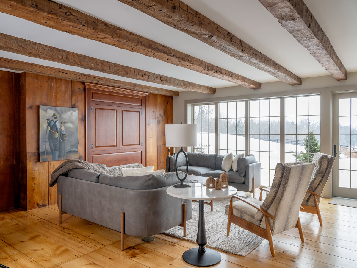 living room overlooking snow outside with dark wood finishes