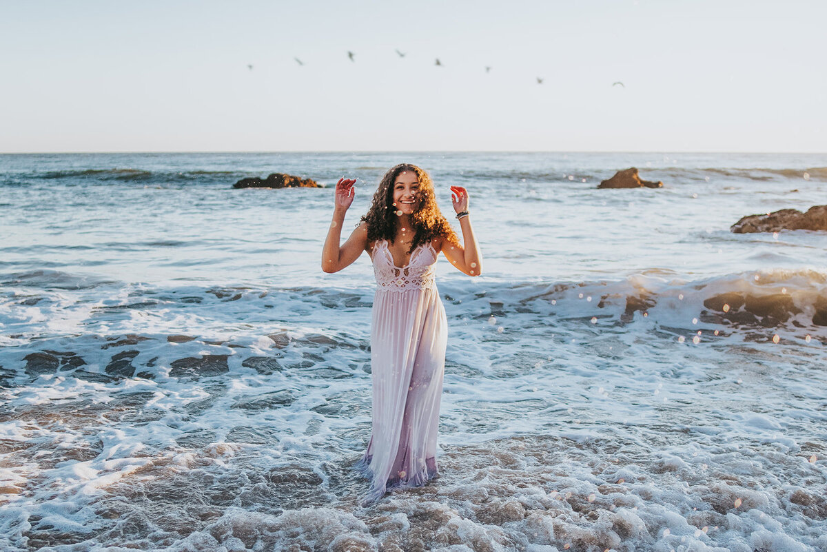 Olivia plays in the water at El Matador State Beach for her senior session.