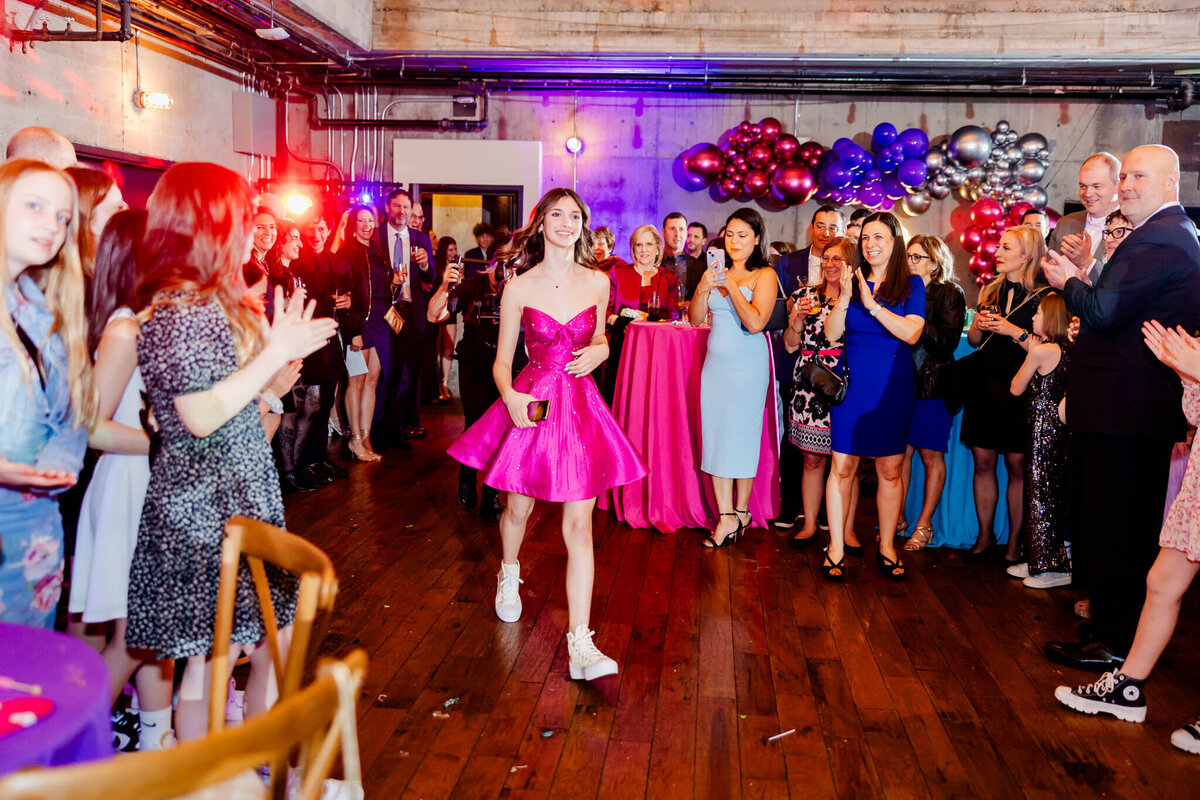 A teen girl in a pink dress enters her party for some Bellevue Bar and Bat Mitzvah Photography