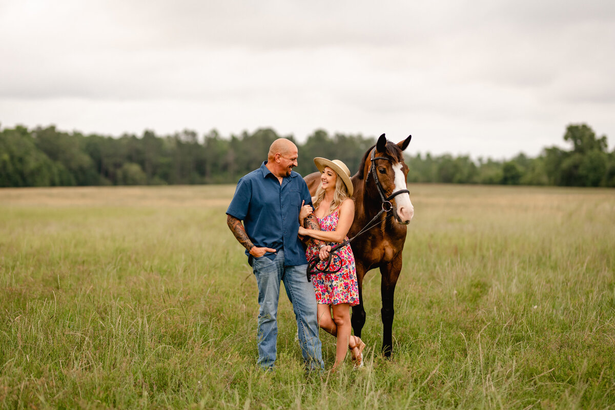 Equine couple takes photos in a field with their horse near Tallahassee, FL.