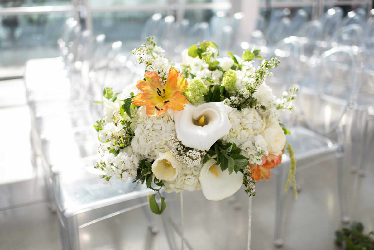 Beautiful spring wedding flowers of white spirea, calla lily, and orange tulips.