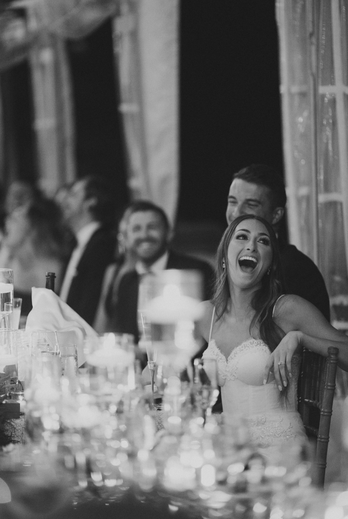 bride and groom laughing during wedding reception speeches