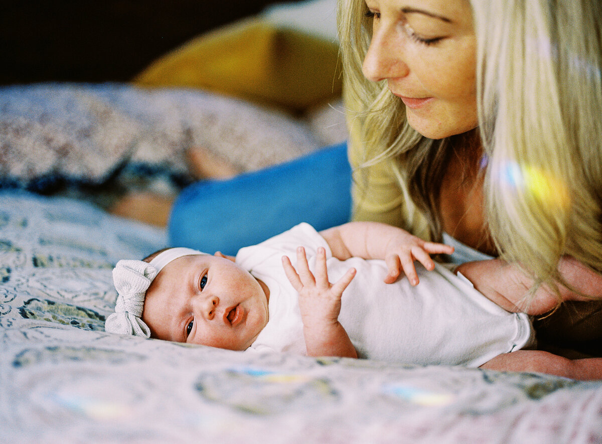 a mom stares down at her newborn baby girl