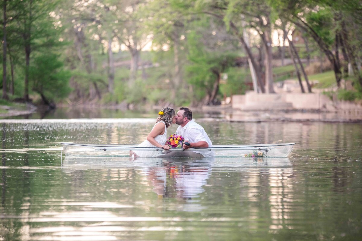 wedding engagement couple kissing in center of clear boat on the Guadalupe river in New Braunfels Texas by firefly photography