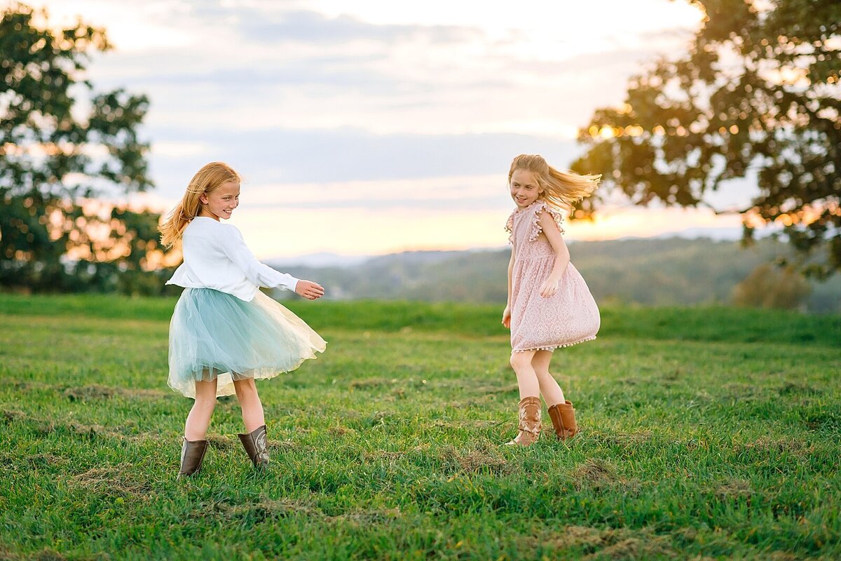 Sisters dancing in a field overlooking the mountains