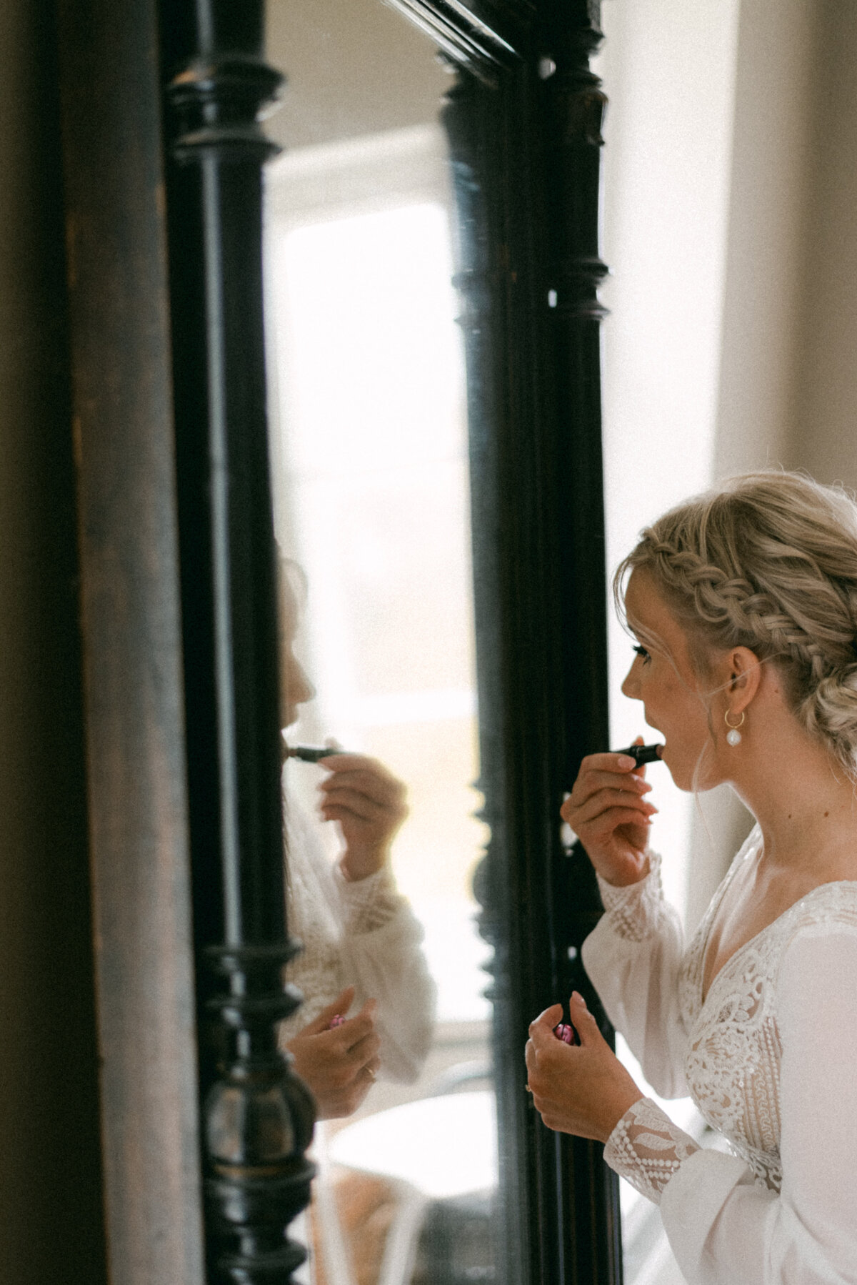A documentary wedding  photo a bride putting on her lipstic in Oitbacka gård captured by wedding photographer Hannika Gabrielsson in Finland