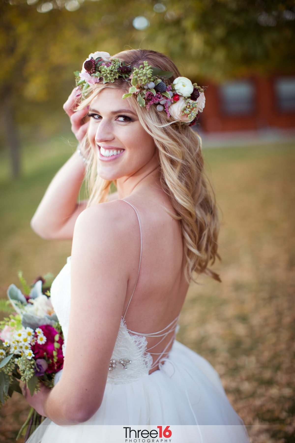 Bride turns and smiles for the camera while holding her bouquet