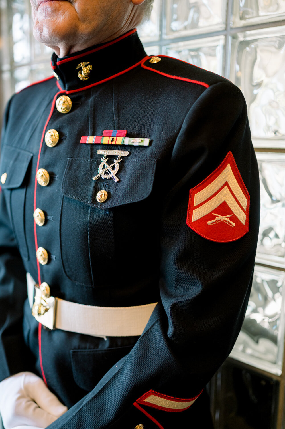 The groom's Marine Corps dress blues adorned with distinguished medals, symbolizing honor and service at a 50th wedding anniversary celebration.
