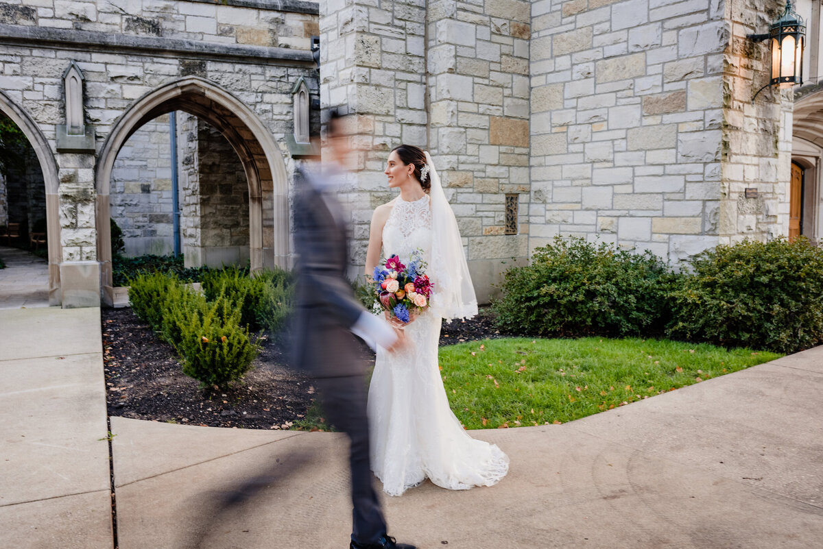 A groom walks past his bride outside a church