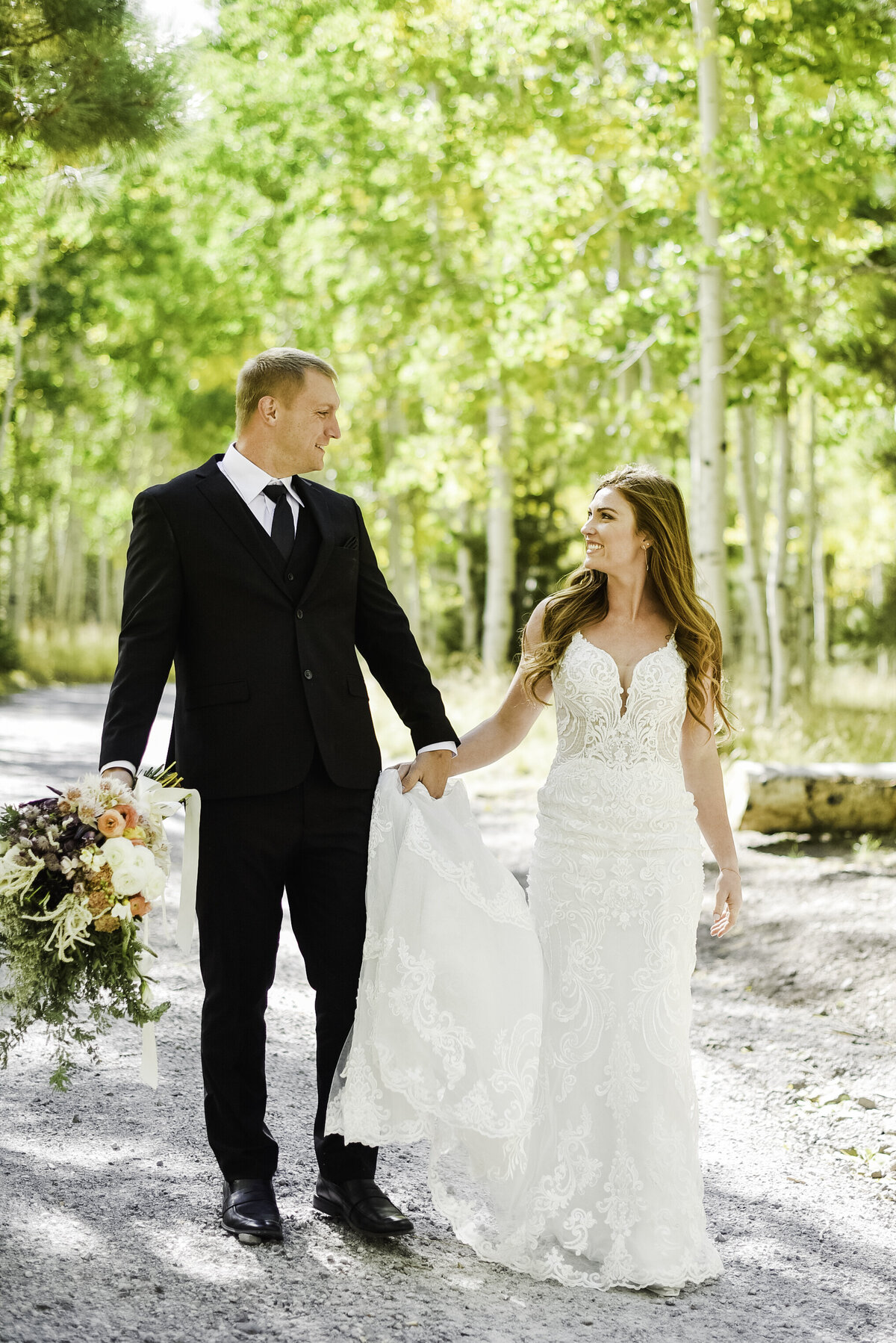 Bride and groom holding hands walking towards camera aspens summer wedding Flagstaff elopement