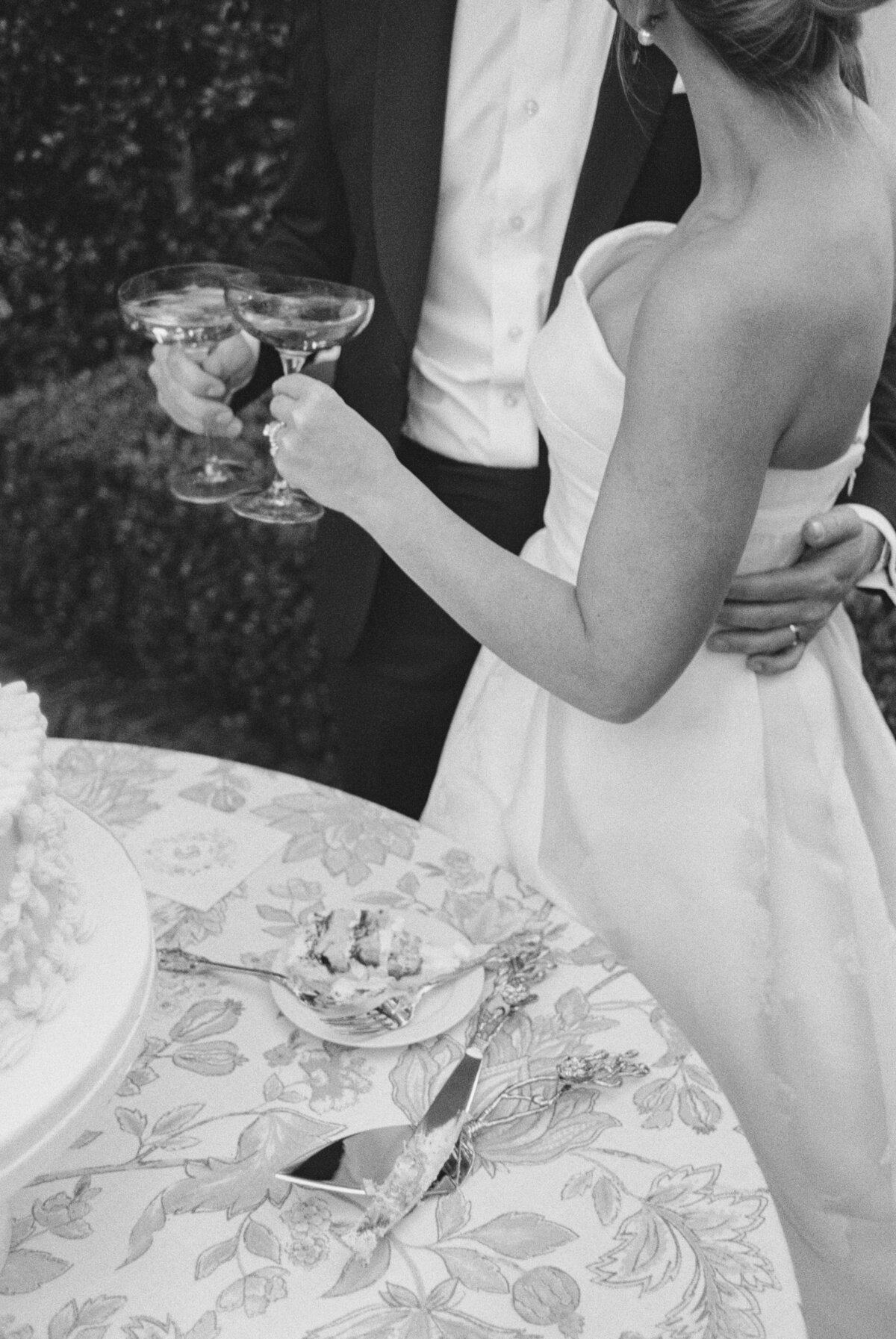 Bride and groom champagne toast after cutting wedding cake.