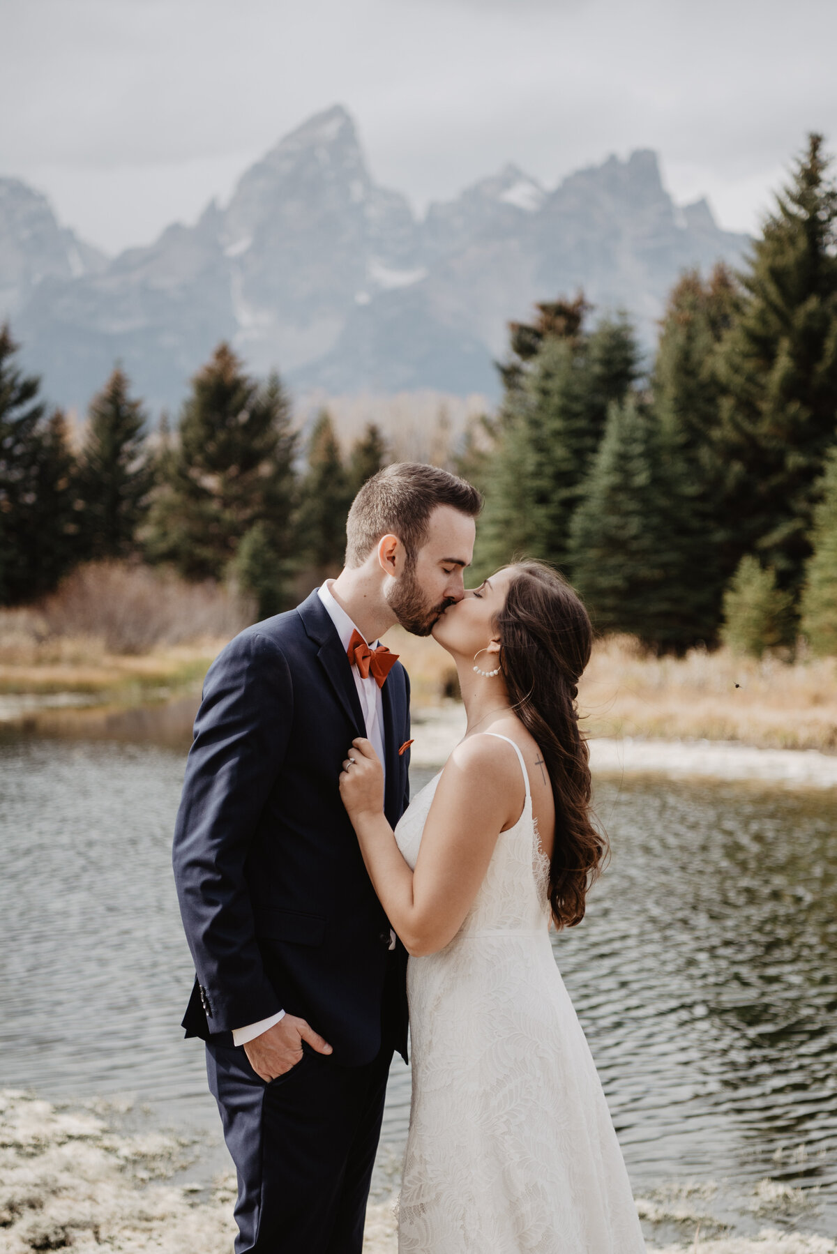 Photographers Jackson Hole capture bride holding groom's lapels kissing him