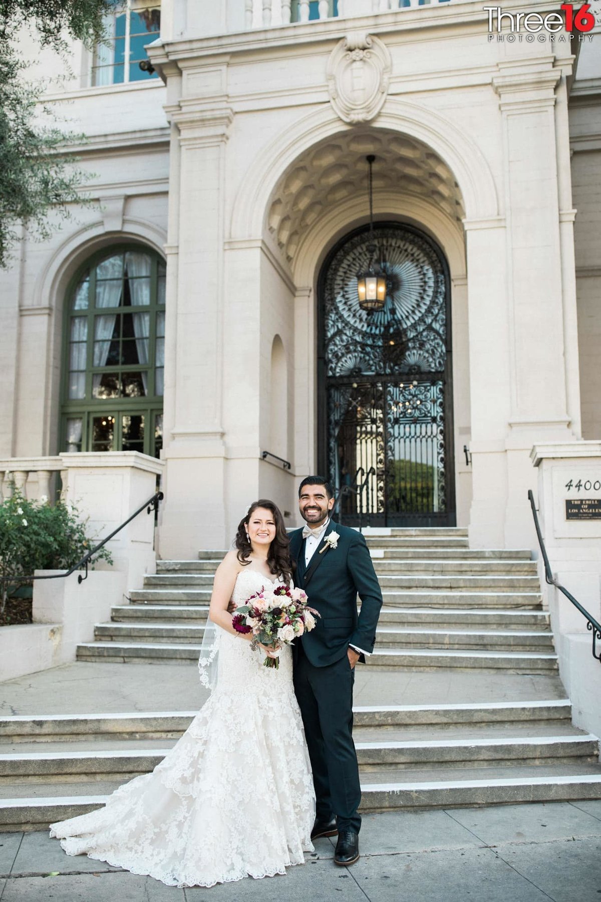 Bride and Groom stand together and pose for photos outside the Ebell Los Angeles wedding venue