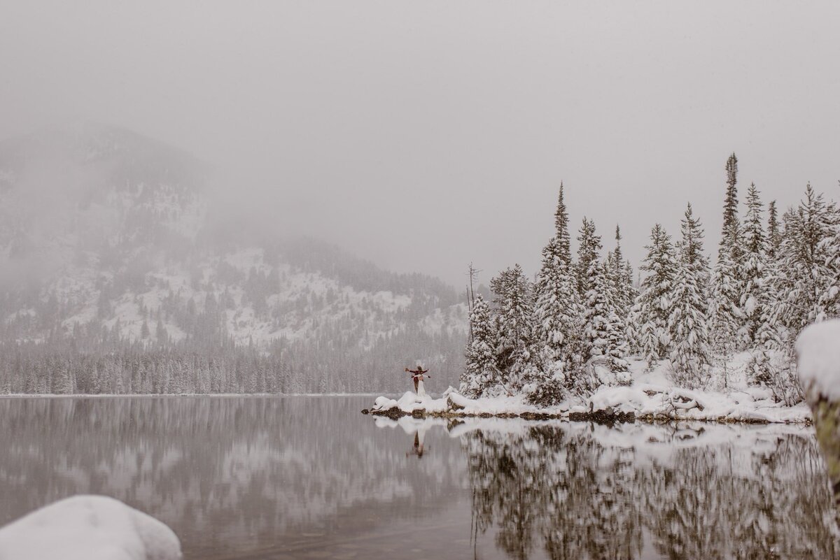 Couple hikes to snowy lake in Grand Teton National Park on their elopement day