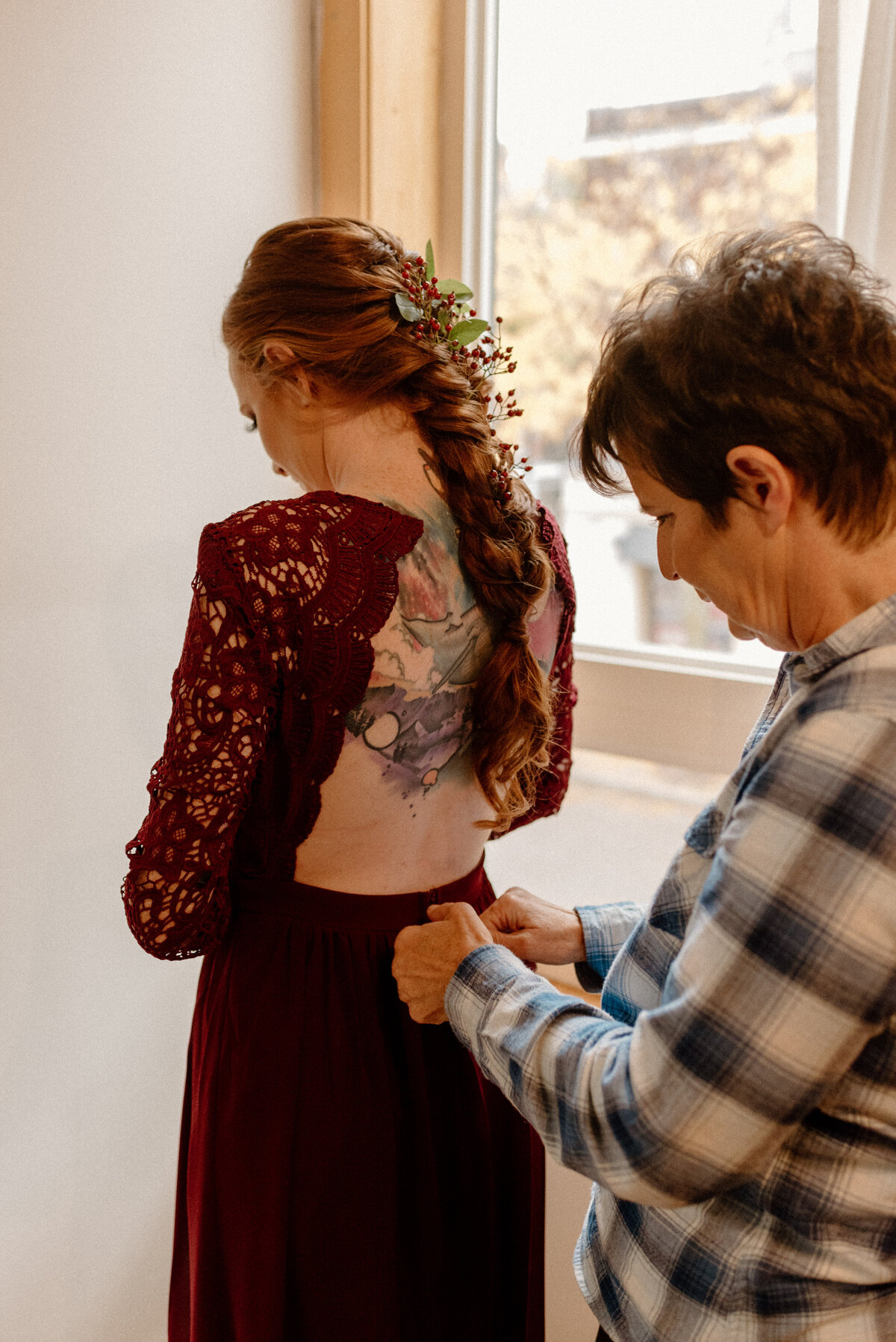 alternative bride's mother helps with her daughter's dress