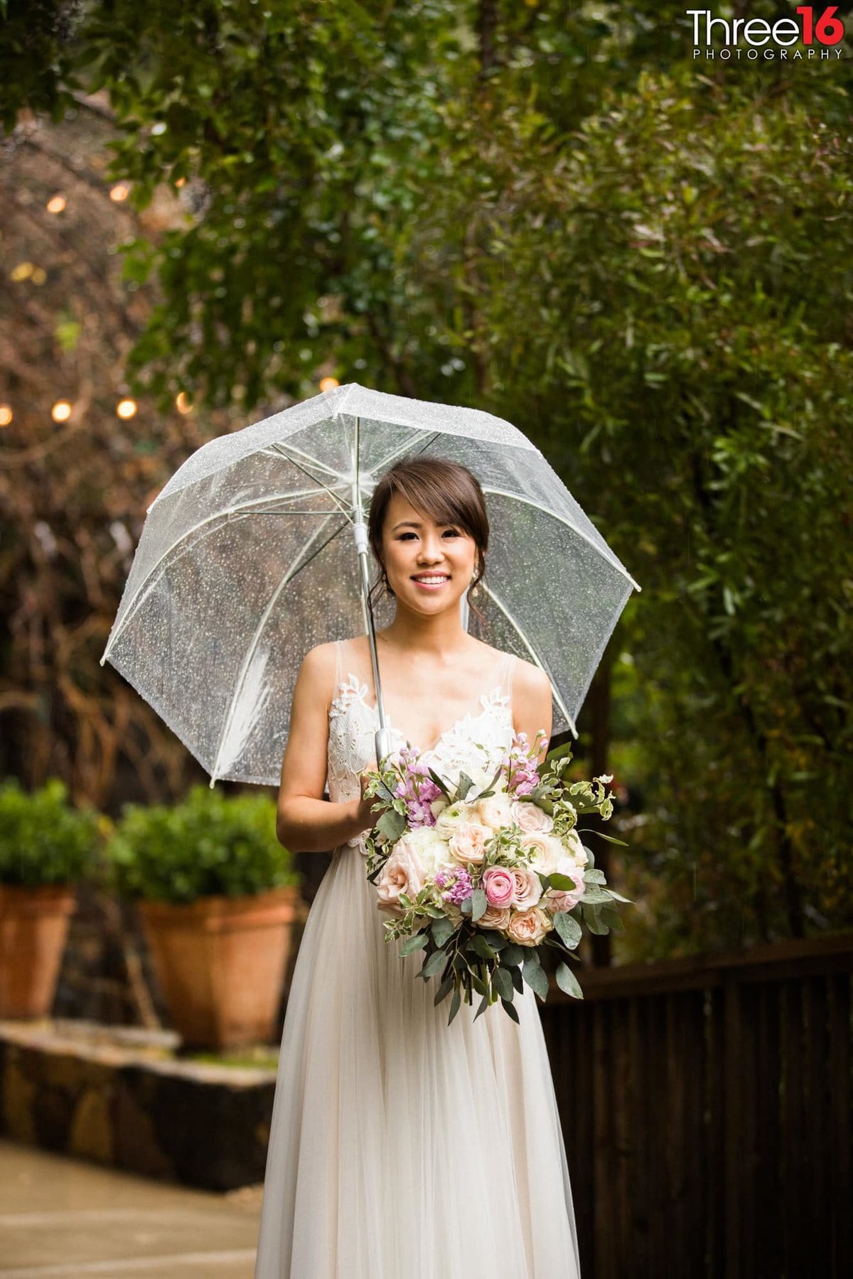 Bride posing with an umbrella and beautiful bouquet of flowers