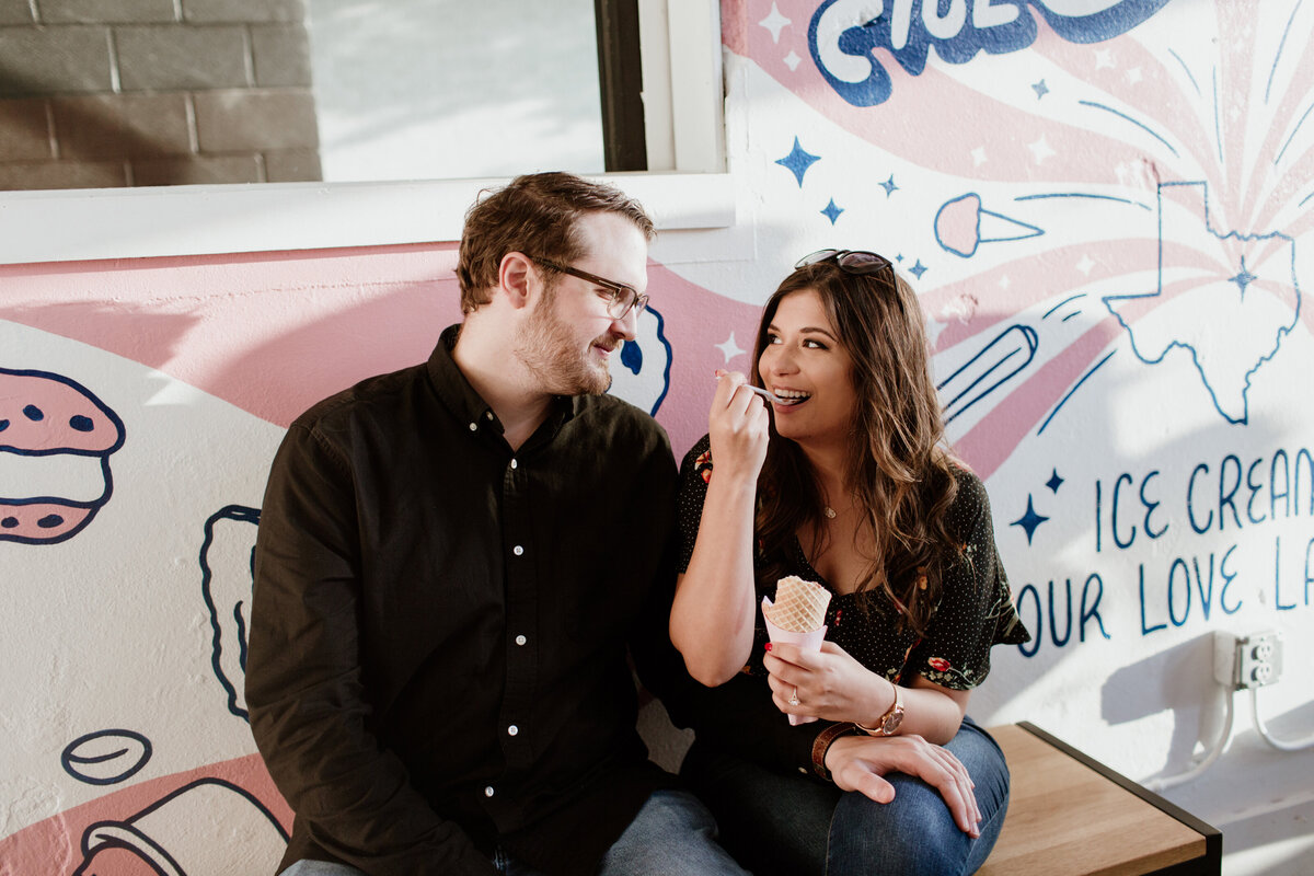 A couple eating ice cream during their South Main engagement session. Captured by Fort Worth Wedding Photographer, Megan Christine Studio