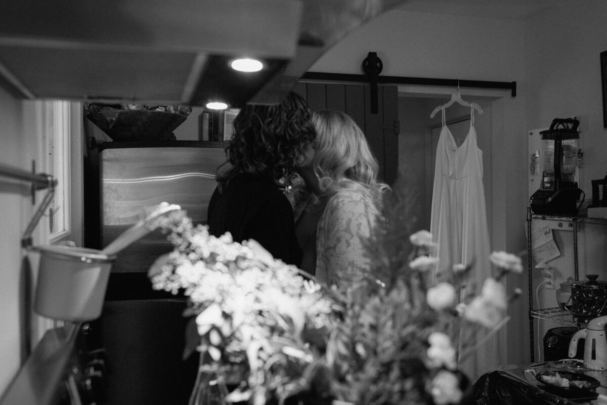 brides kissing in the kitchen