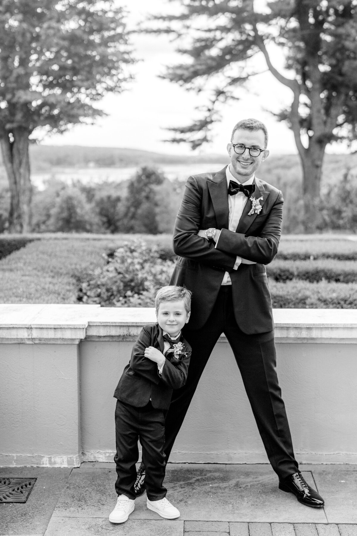 Groom and ring bearer posing in their tuxes