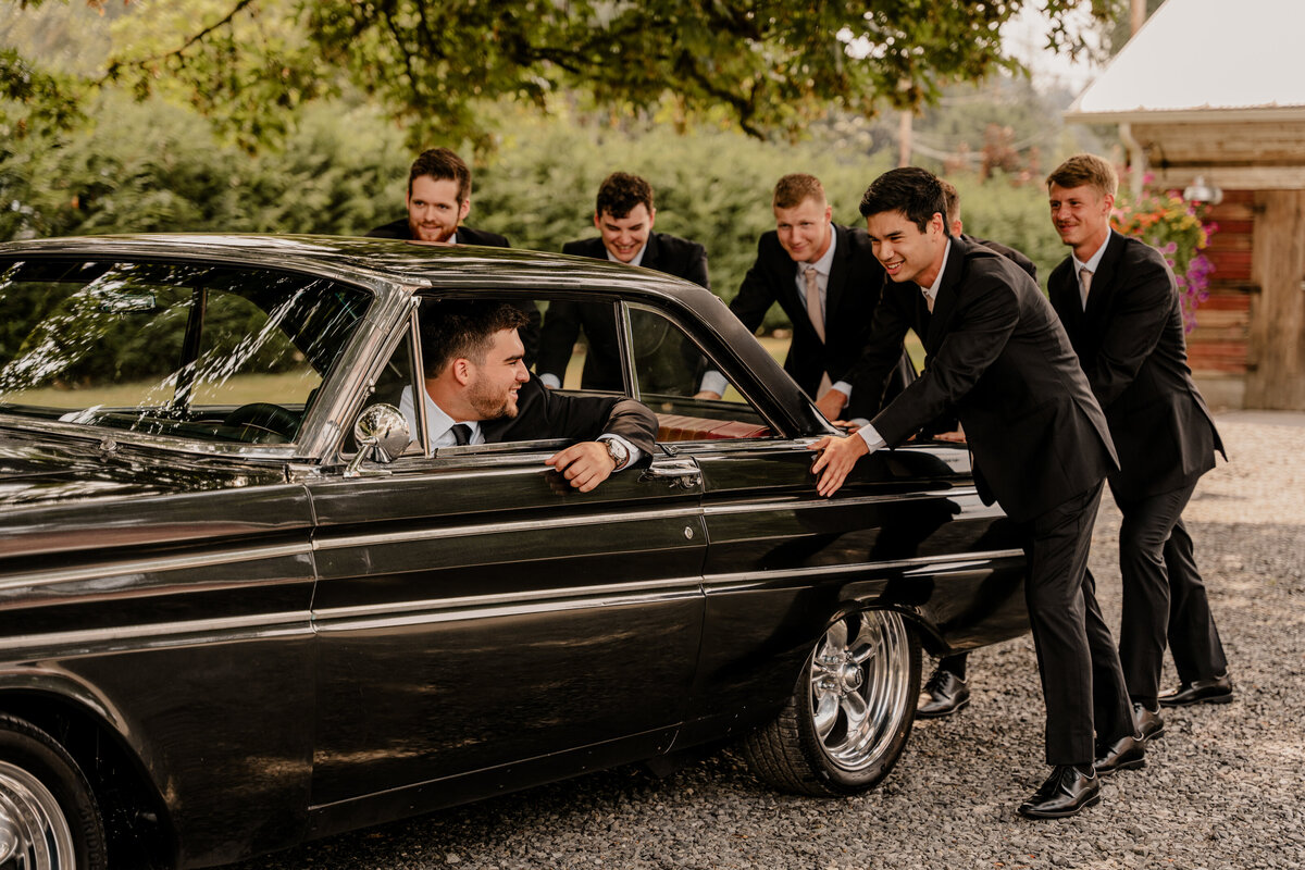 The groomsmen pose with a classic car at Machias Meadows in Snohomish, Washington.